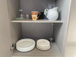 une étagère avec des assiettes et un vase sur elle dans l'établissement Ap encantador a 100 m da praia Costazul | ROBD201, à Rio das Ostras 38 autres photos