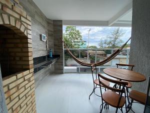 um quarto com uma mesa e cadeiras e uma lareira em Apto de alto padrão 100 m da Praia de Costazul - WIFI 200MB - TV Smart - 2 Quartos - Garagem - Cozinha equipada - Churrasqueira em Rio das Ostras