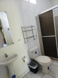 a bathroom with a toilet and a sink at Aparta Hotel Palmerola in Comayagua
