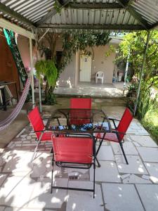 a group of red chairs and a table on a patio at Aparta Hotel Palmerola in Comayagua
