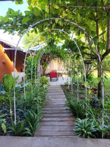 a wooden pathway through a garden with a pergola at Aparta Hotel Palmerola in Comayagua