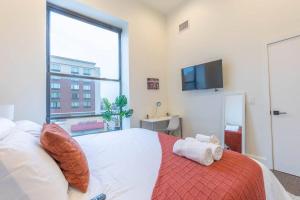 - une chambre avec un lit et une grande fenêtre dans l'établissement Downtown Beauty mins to Airport+FREE Parking+Games, à Newark