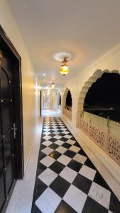a hallway with a black and white checkered floor at The Grand Barso (A Luxury Heritage) in Bharatpur