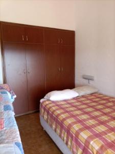 1 dormitorio con 1 cama y armarios de madera en Vistas de Embalsina en Villa del Dique