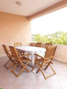 stół i 4 krzesła na werandzie ze stołem i krzesłami w obiekcie comfortable appartment close to the beach w mieście Isola Rossa