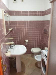 W łazience znajduje się umywalka, toaleta i pralka. w obiekcie comfortable appartment close to the beach w mieście Isola Rossa