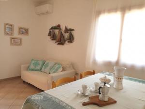 salon ze stołem i kanapą w obiekcie comfortable appartment close to the beach w mieście Isola Rossa