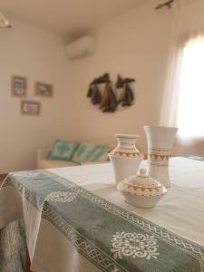 Stolik z dwoma wazami na górze w obiekcie comfortable appartment close to the beach w mieście Isola Rossa