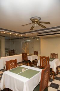 comedor con mesas y sillas y ventilador de techo en Hotel Salvador Catamarca en San Fernando del Valle de Catamarca