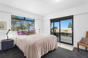a bedroom with a bed and a large window at Kate and Harrys in Opotiki