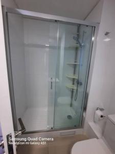 een glazen douche in een badkamer met een toilet bij Departamento Nuevo con hermosa vista! in Concón