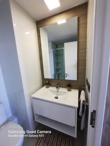a bathroom with a white sink and a mirror at Departamento Nuevo con hermosa vista! in Concón