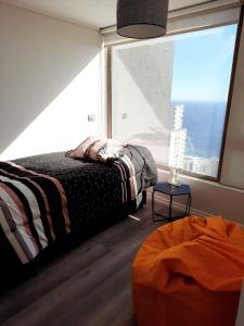 a bedroom with a bed and a large window at Departamento Nuevo con hermosa vista! in Concón