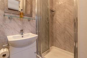 W łazience znajduje się umywalka i prysznic. w obiekcie Glyntwrog House w mieście Betws-y-coed