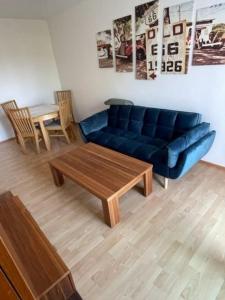 a living room with a blue couch and a coffee table at City Appartement 4600 in Wels