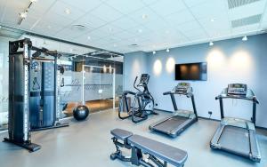 a gym with cardio equipment in a room with blue walls at Zleep Madrid Airport in Madrid