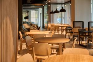 una fila de mesas y sillas en un restaurante en Zleep Madrid Airport, en Madrid