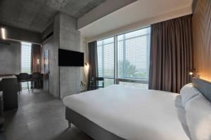 a bedroom with a white bed and a large window at Zleep Madrid Airport in Madrid +40 photos