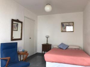 a bedroom with a bed and a blue chair at Hotel Rid in Mar del Plata