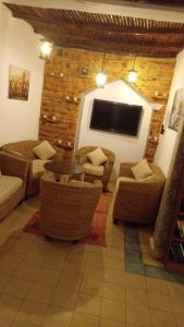 a living room with couches and a flat screen tv at La colina House taghazout in Taghazout