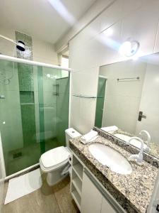 y baño con lavabo, aseo y espejo. en Andrei Noriller Orla Praia Grande, en Arraial do Cabo