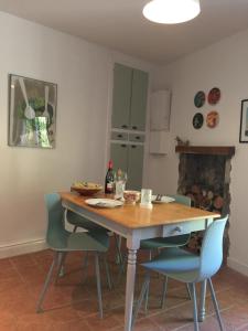 une cuisine avec une table en bois et des chaises bleues dans l'établissement Le Gite du Petit Renard: A Tranquil Gite with pool, à Oradour-Saint-Genest