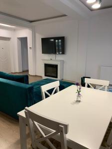 HAPPY SUMMER -Predeal في بريدال: غرفة معيشة مع طاولة بيضاء وأريكة زرقاء