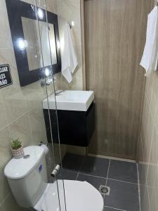 Łazienka z białą toaletą i umywalką w obiekcie Lindo Apartaestudio cerca al centro w mieście Itagüí