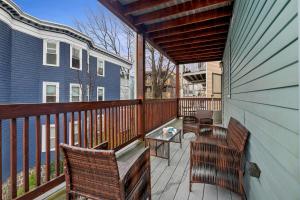 a balcony with chairs and a table on a deck at Bright & Spacious 2Br apartment, mins from Downtown Boston, parking in Boston