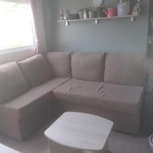 ein weißes Sofa im Wohnzimmer mit einem Tisch in der Unterkunft Domaine in Litteau