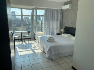 a hotel room with a bed and a table with chairs at Savassi Village in Belo Horizonte +38 photos