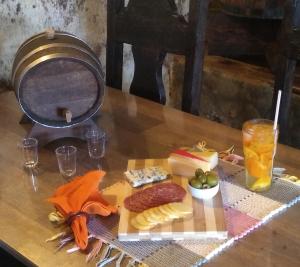 ein Teller mit Lebensmitteln auf einem Tisch mit Fleisch und Käse in der Unterkunft Pouso do Tropeiro - Cavalgadas Roseta in Baependi