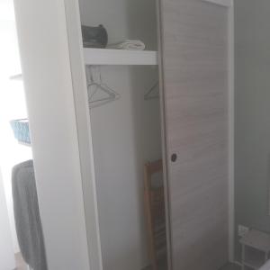 einen kleinen Schrank mit einer Tür und einem Regal in der Unterkunft Domaine in Litteau