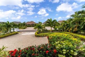 a park with flowers and palm trees and a car at Richmond Estate With Pool House in Ocho Rios