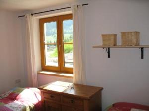 1 dormitorio con ventana, tocador de madera y cama en Annaberg TOP 1, en Annaberg im Lammertal