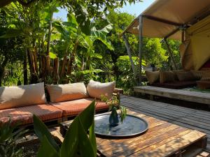 a patio with a couch and a table with a coffee table at Campo Portakal Eco Glamping in Cıralı