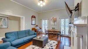 un soggiorno con divano blu e tavolo di Comfortable Escape in Historic Downtown Savannah a Savannah