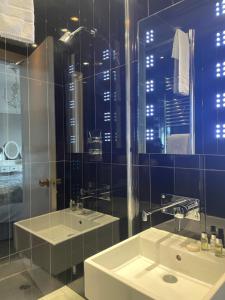 a bathroom with two sinks and a glass shower at The Lilly Restaurant With Rooms in Llandudno