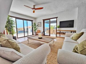 un soggiorno con due divani bianchi e un tavolo di No 2. Stunning 4-Bedroom Villa with Large Pool a La Oliva