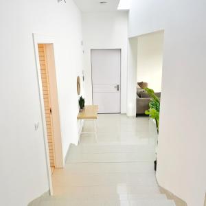 Luz Mansion ~ Lux & Comfy في ريشون ليزيون: غرفة معيشة بجدران بيضاء وأرضية بيضاء