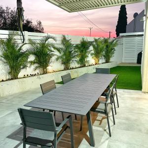 una mesa y sillas en un patio con vistas a la puesta de sol en Luz Mansion ~ Lux & Comfy, en Rishon LeZion