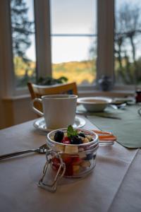 einen Tisch mit einer Schale Obst und einer Tasse Kaffee in der Unterkunft Glyntwrog House in Betws-y-coed