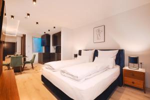 a bedroom with a bed with white sheets and a table at Loft Suite im modernen Style in Schärding in Schärding