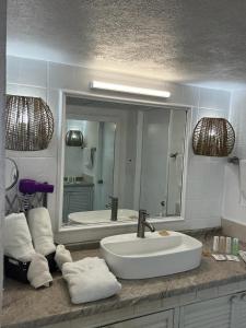 een badkamer met een wastafel en een grote spiegel bij BEACHFRONT 14 Floor in Puerto Vallarta