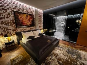 a bedroom with a bed and a brick wall at Mandarin Club House in Batumi