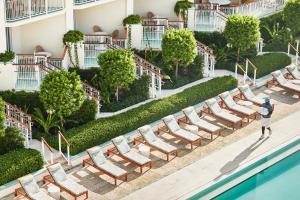 uma fila de espreguiçadeiras ao lado de uma piscina num hotel em Four Seasons Resort Palm Beach em Palm Beach