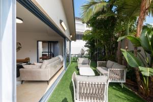 un patio al aire libre con sillas, mesas y césped en O&O Group - Huge Villa With Jacuzzi By The Beach, en Rishon LeZion