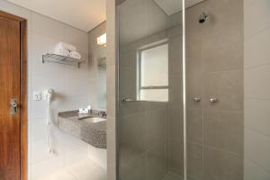 een badkamer met een douche en een wastafel bij Saint Emilion by Atlantica in Curitiba