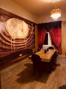 une salle à manger avec une table et une grande fresque murale. dans l'établissement LA MARIEFACTURE - Comme un Livre Ouvert, à La Petite-Pierre