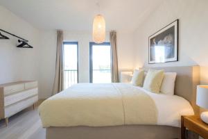 una camera bianca con un letto e una finestra di Lumineux Appartement 1 chambre proche Ecole Européenne a Bruxelles